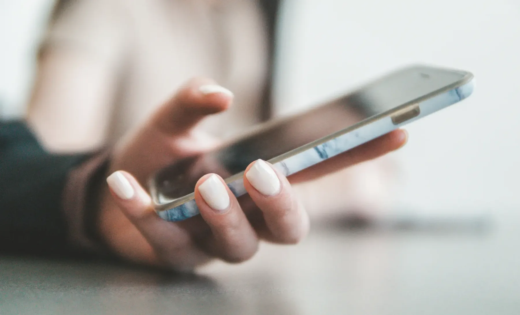 Shopper holding a smartphone to browse a store homepage on a mobile layout