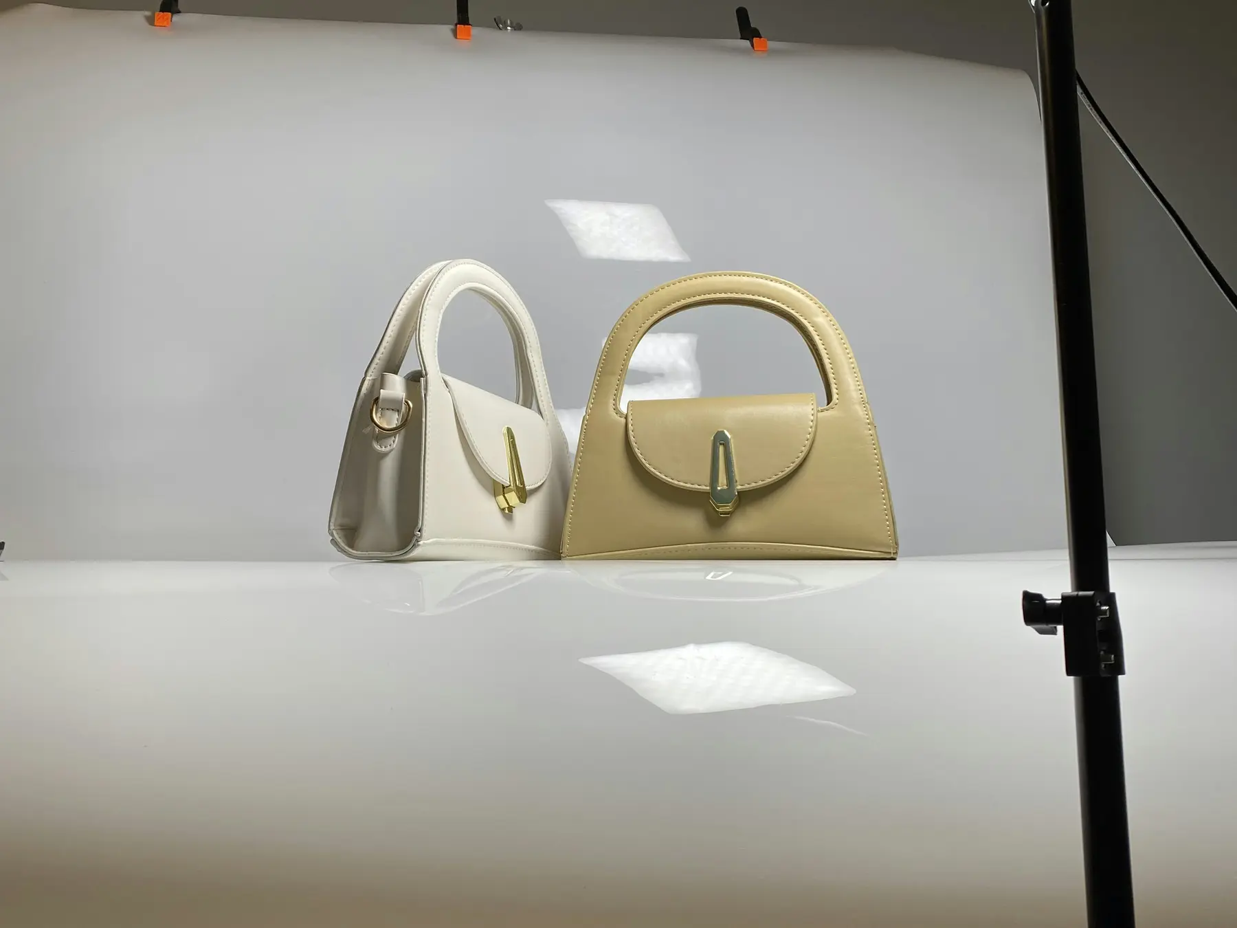 A product photography setup with a light and a bag on a white sweep, the kind of shot that answers shopper questions