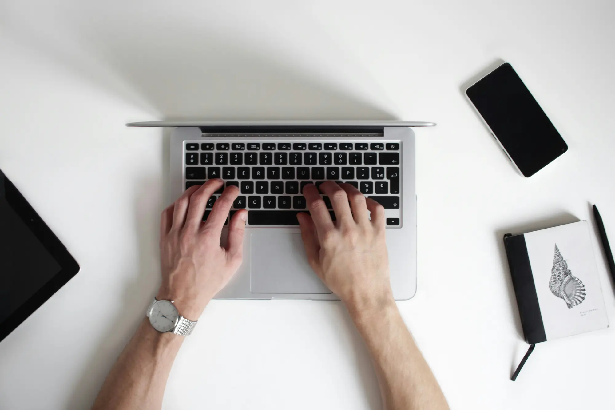 Hands typing on a laptop while writing a Shopify collection page description